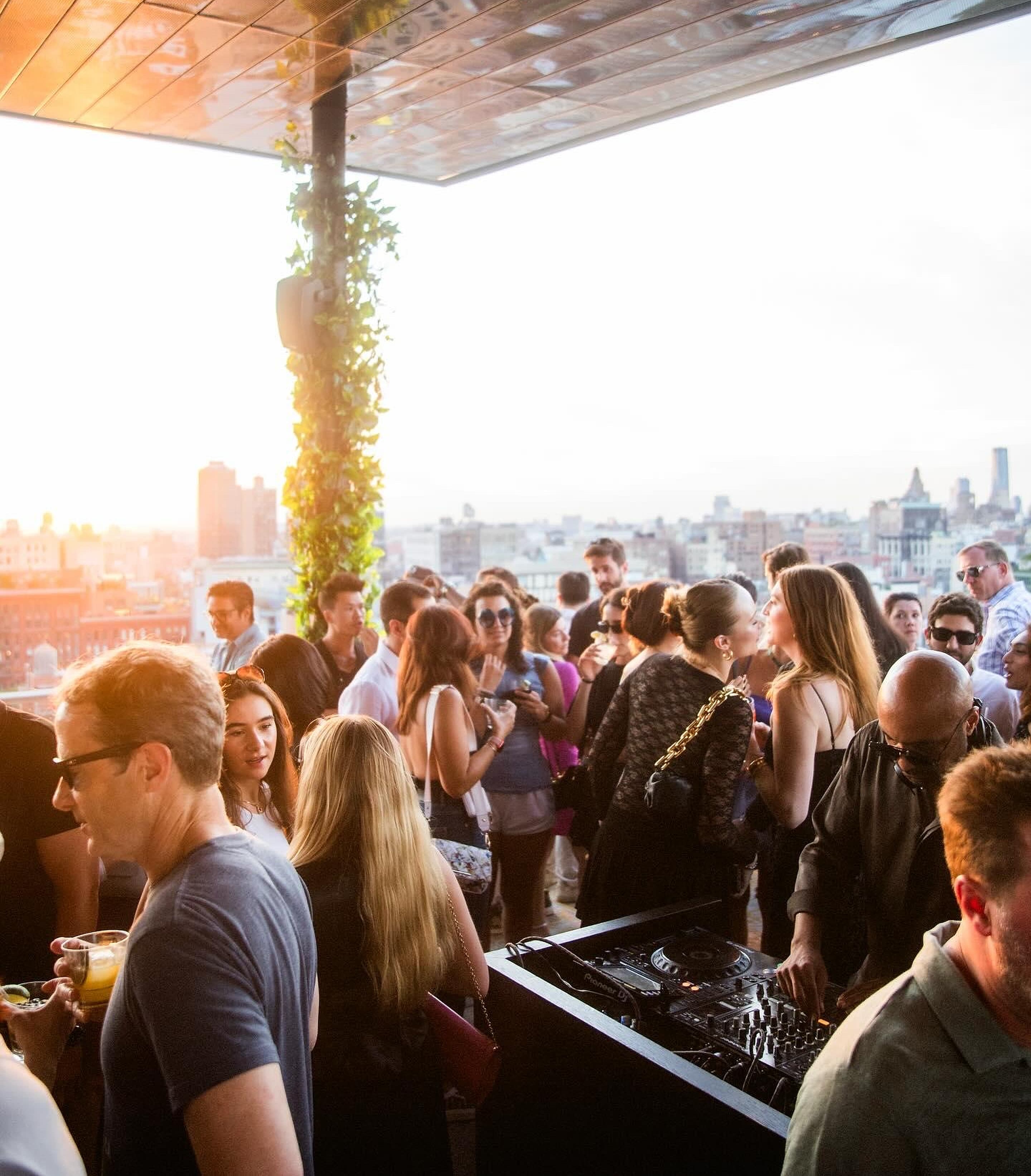 Golden-hour rooftop crowd with New York atmosphere